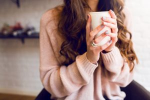 lady in pink sweater holding coffee
